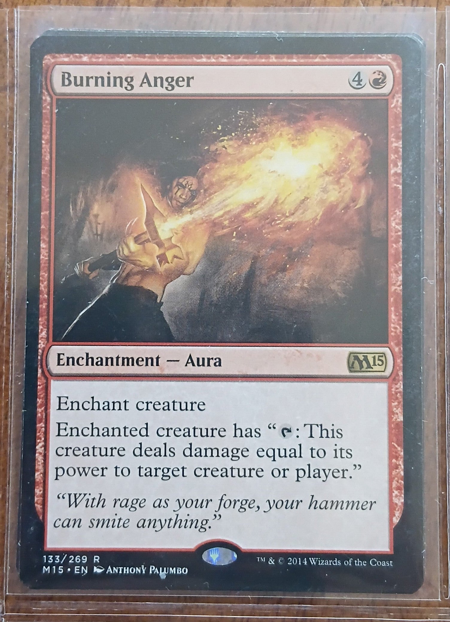 Trading card titled 'Burning Anger' with artwork of a character and text on a wooden surface.